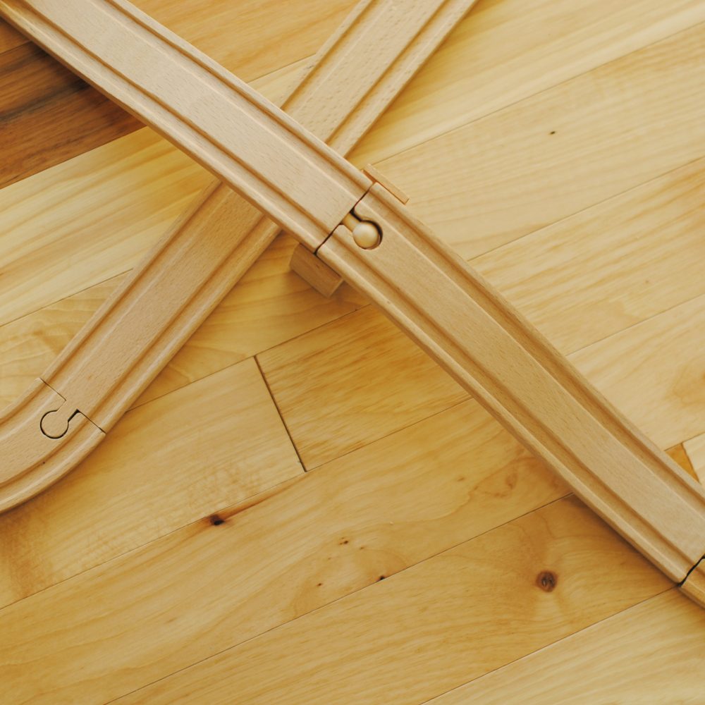 Wooden train track on a pale wooden floor