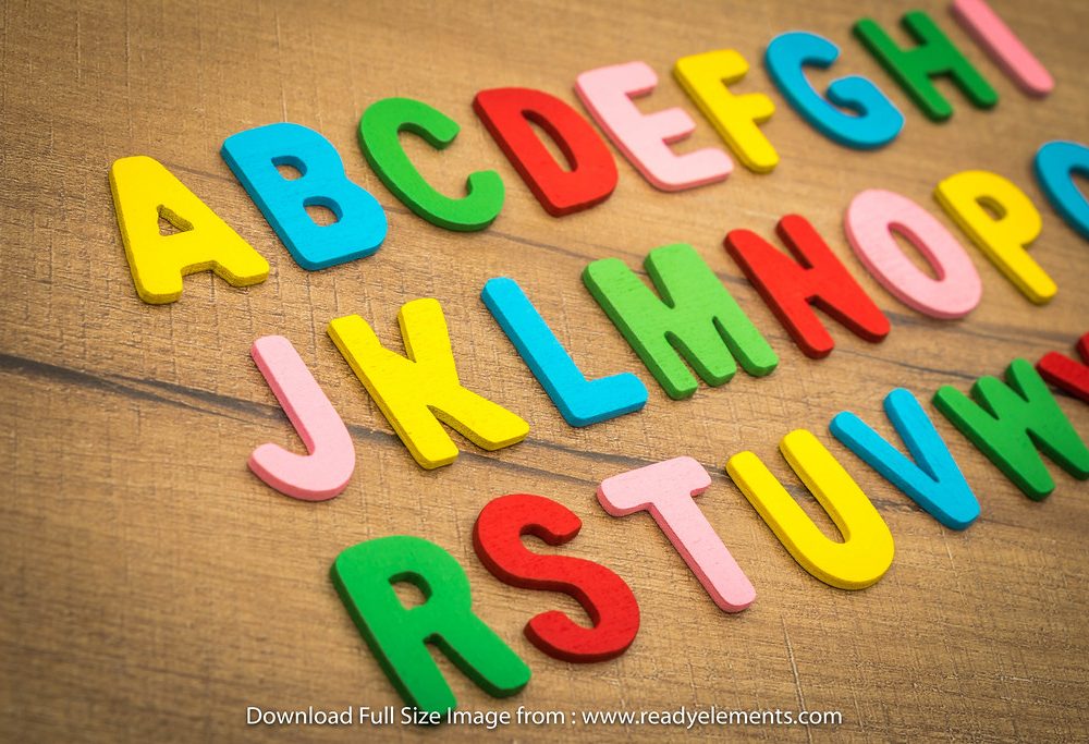Bright foam alphabet letters on a wooden table